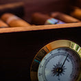 A humidor full of cigars showing a hygrometer.