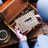 Person holding a Boveda Size 320 69RH above a humidor with cigars in it.