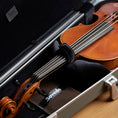 Boveda fabric holder resting in a violin case beneath a violin.